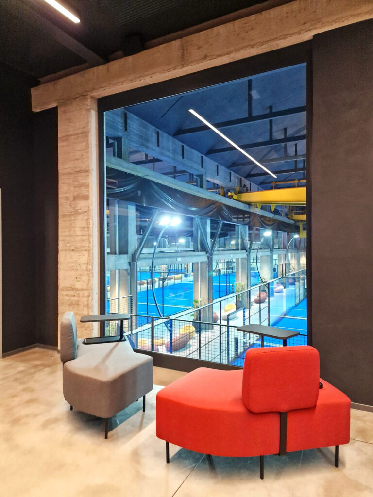 Open space uffici centro sportivo Como con phone booth fonoassorbenti, area lounge e sala riunioni flessibile