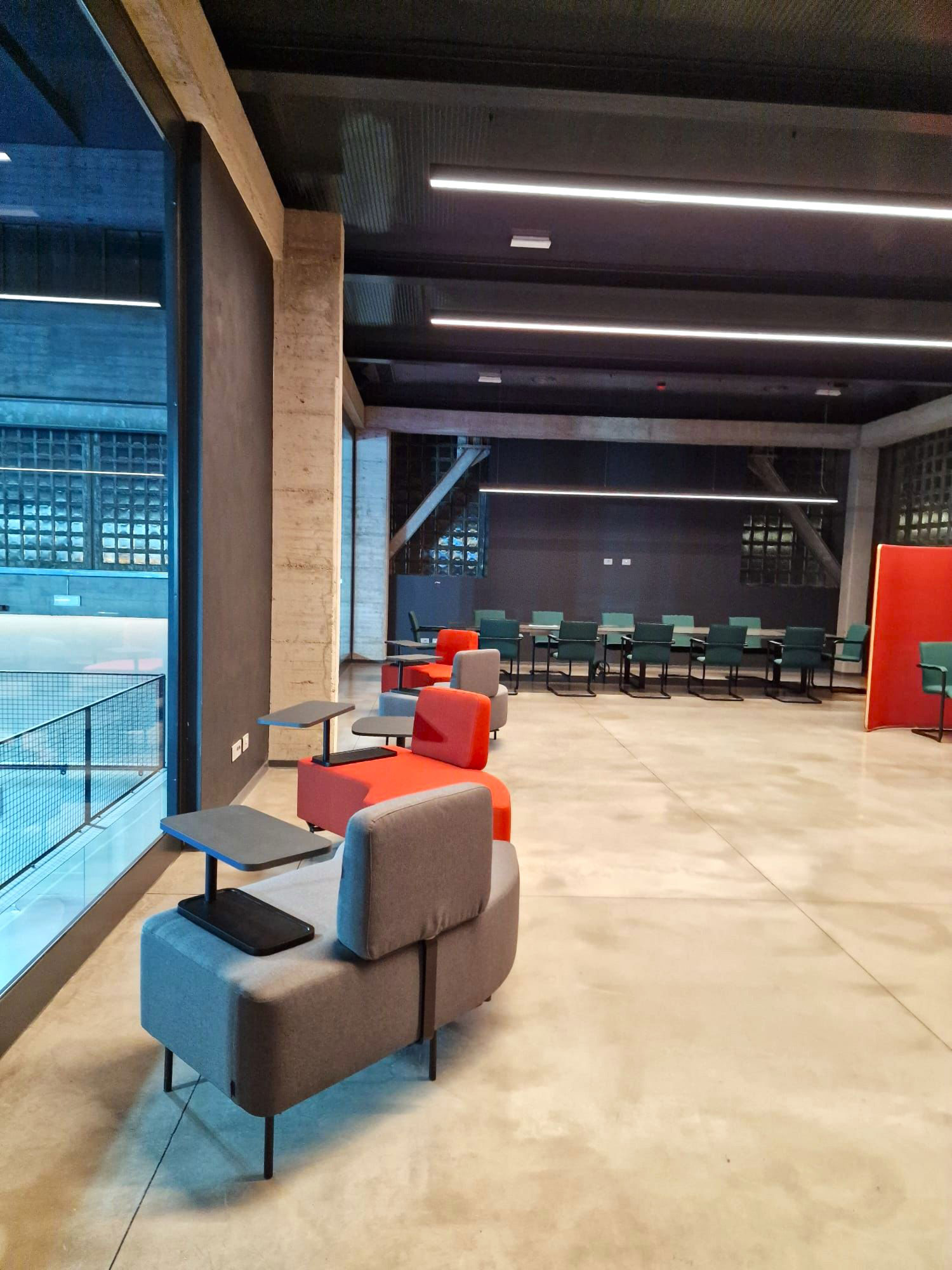 Open space uffici centro sportivo Como con phone booth fonoassorbenti, area lounge e sala riunioni flessibile