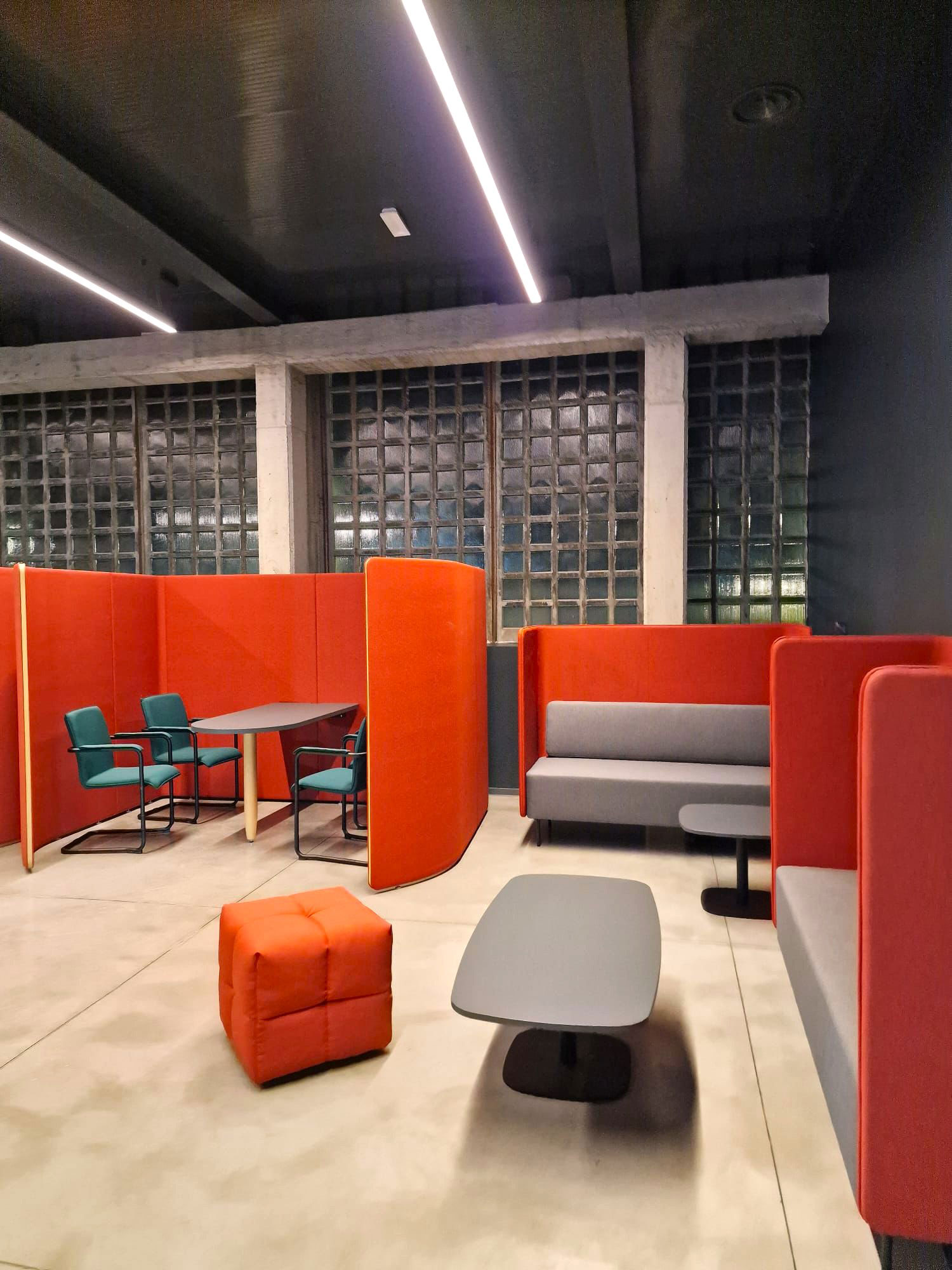 Open space uffici centro sportivo Como con phone booth fonoassorbenti, area lounge e sala riunioni flessibile