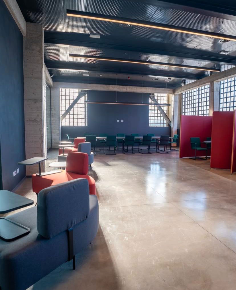 Open space uffici centro sportivo Como con phone booth fonoassorbenti, area lounge e sala riunioni flessibile