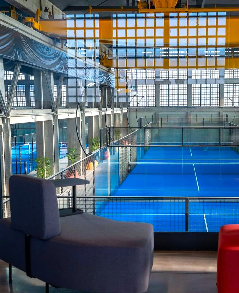 Open space uffici centro sportivo Como con phone booth fonoassorbenti, area lounge e sala riunioni flessibile