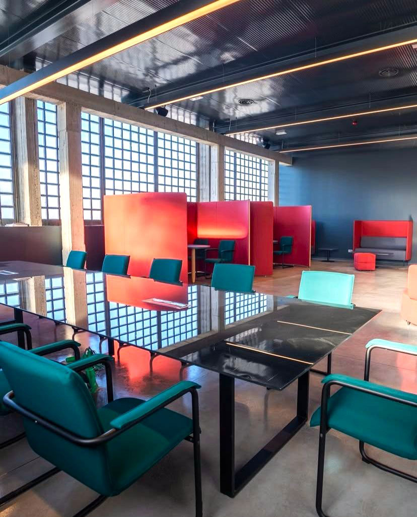 Open space uffici centro sportivo Como con phone booth fonoassorbenti, area lounge e sala riunioni flessibile