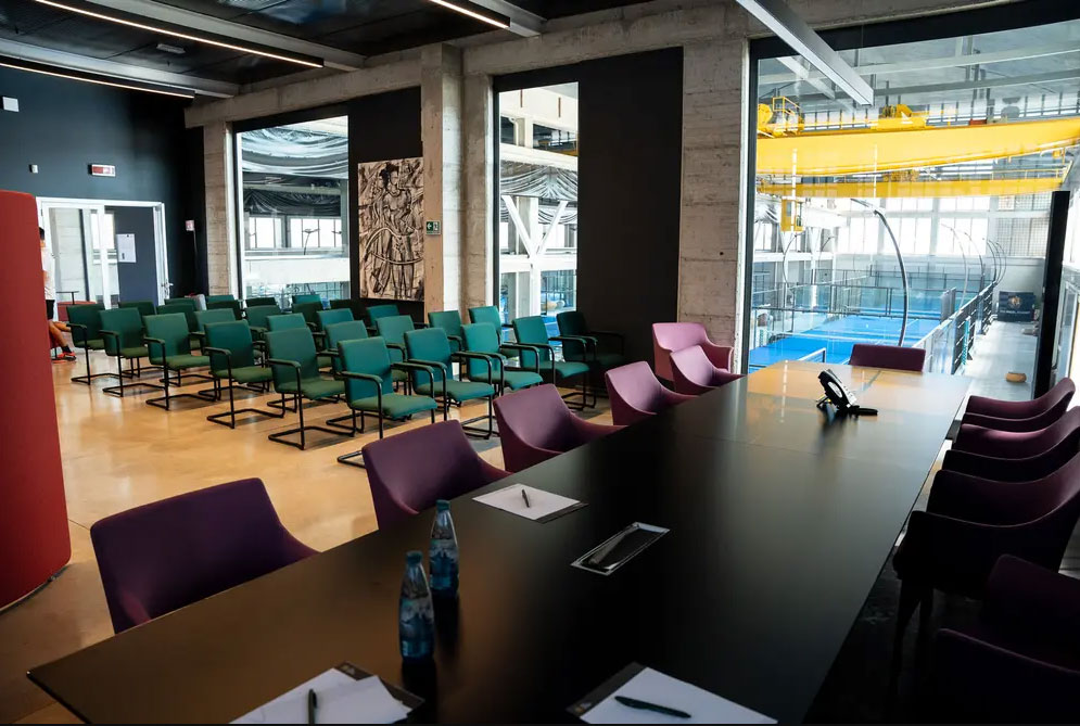 Open space uffici centro sportivo Como con phone booth fonoassorbenti, area lounge e sala riunioni flessibile