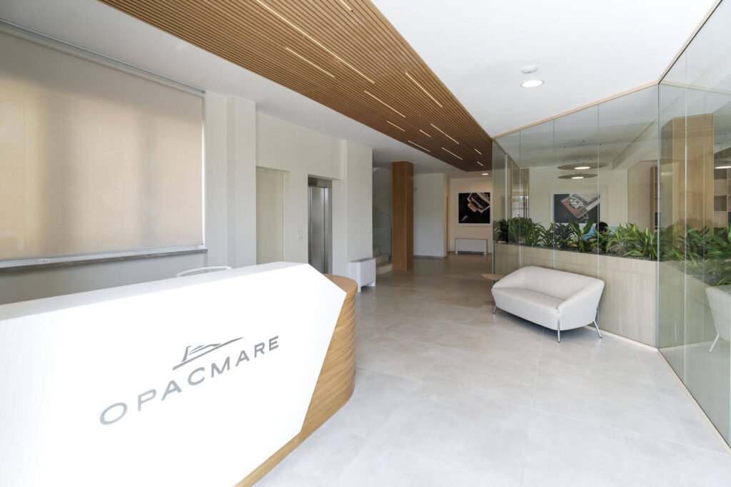 Ufficio Opac Mare con pareti vetrate effetto legno, reception su misura e sale riunioni eleganti