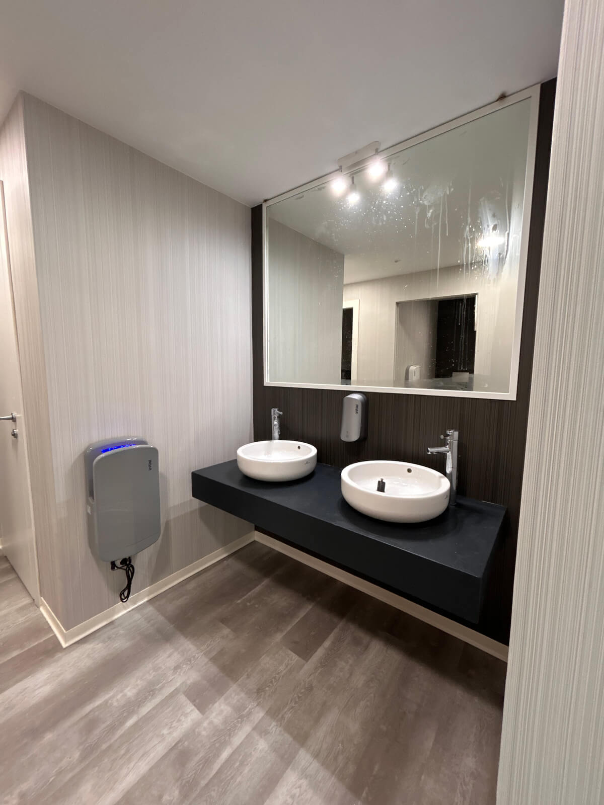 Allestimento ufficio Solco con pareti vetrate, postazioni operative, area lounge e arredi moderni