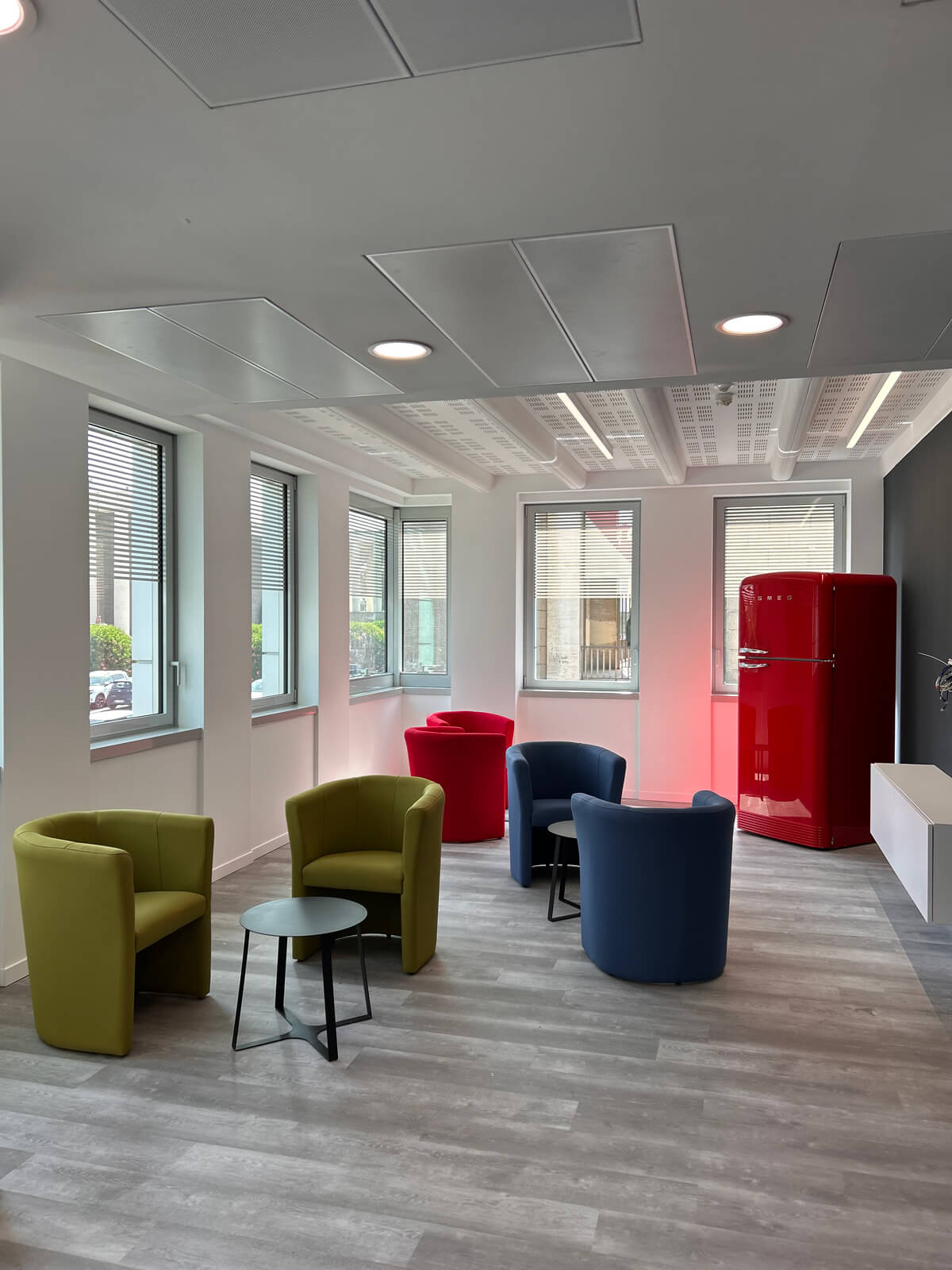 Allestimento ufficio Solco con pareti vetrate, postazioni operative, area lounge e arredi moderni