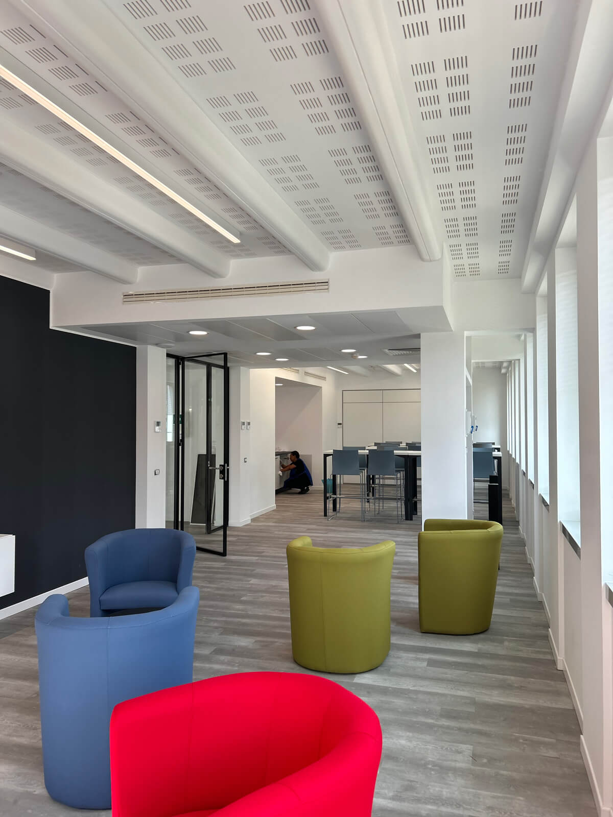 Allestimento ufficio Solco con pareti vetrate, postazioni operative, area lounge e arredi moderni