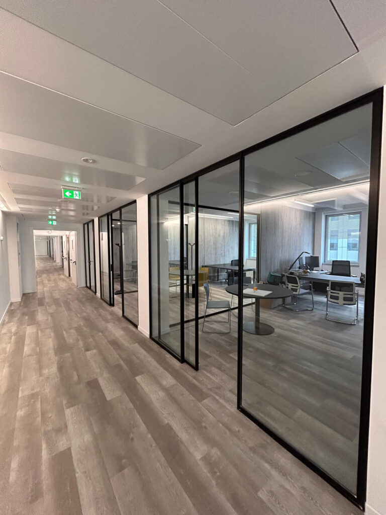 Allestimento ufficio Solco con pareti vetrate, postazioni operative, area lounge e arredi moderni