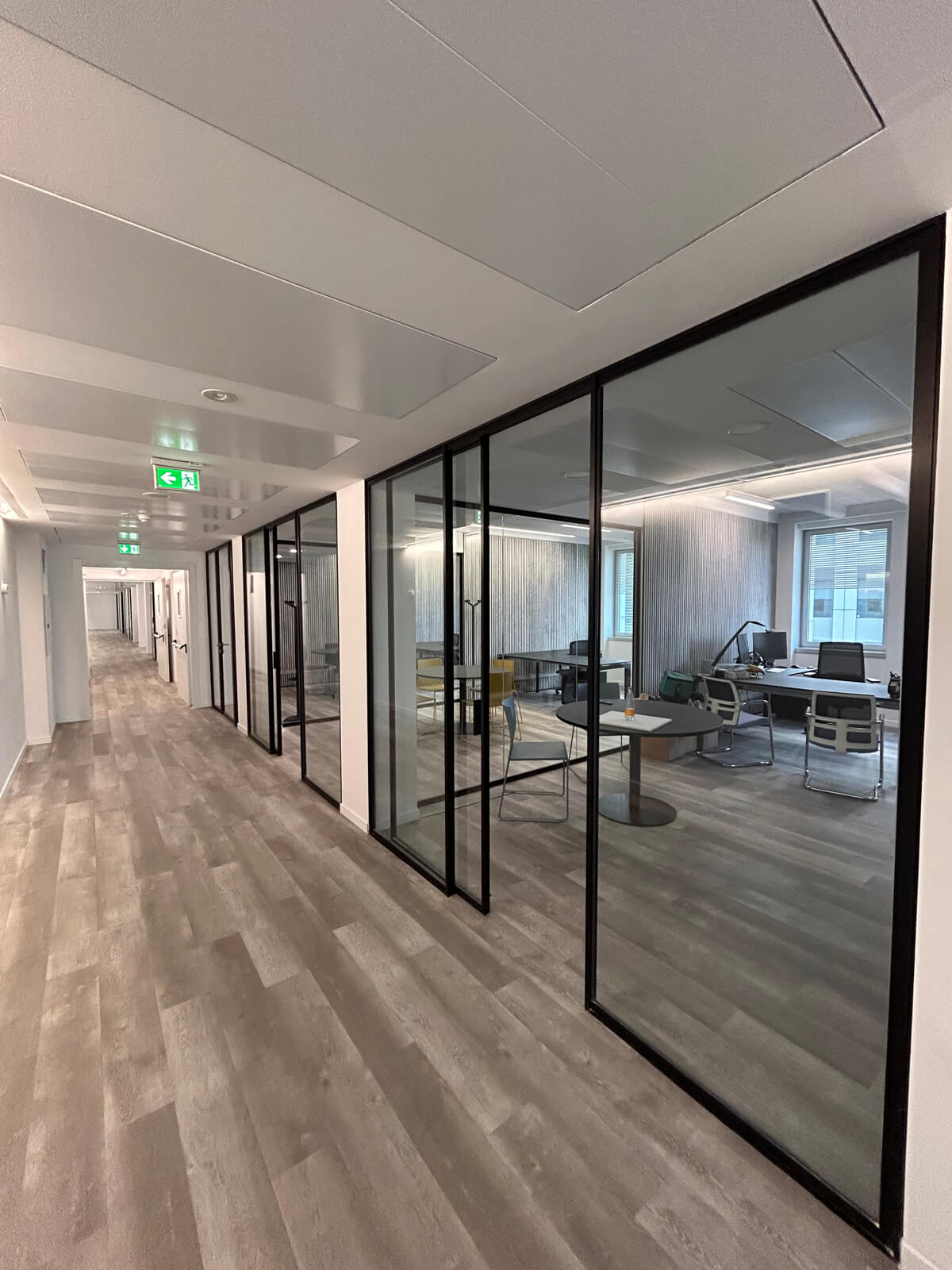 Allestimento ufficio Solco con pareti vetrate, postazioni operative, area lounge e arredi moderni