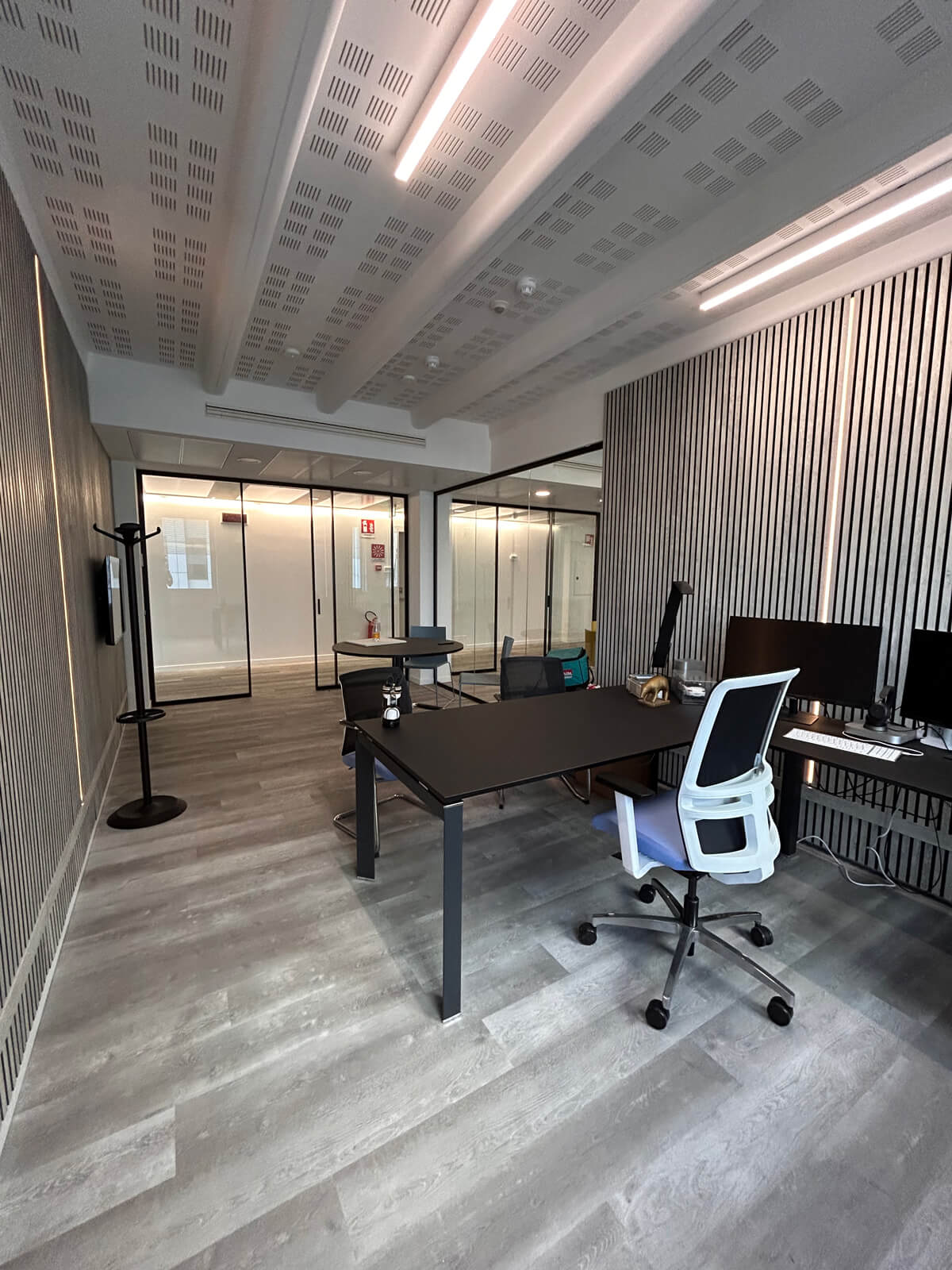 Allestimento ufficio Solco con pareti vetrate, postazioni operative, area lounge e arredi moderni