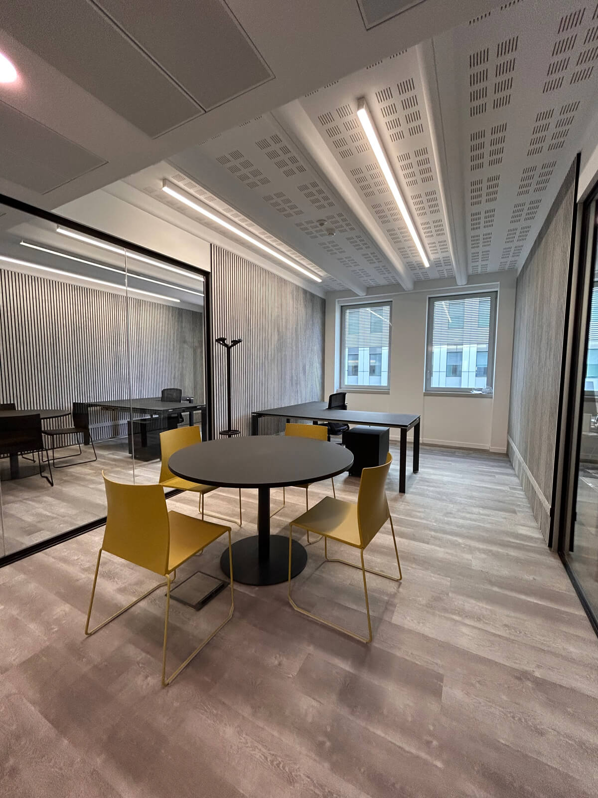 Allestimento ufficio Solco con pareti vetrate, postazioni operative, area lounge e arredi moderni