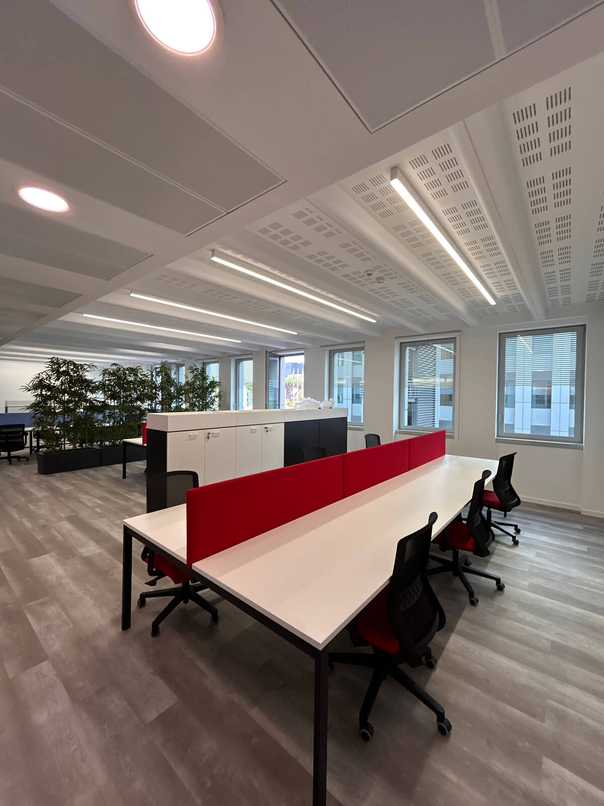 Allestimento ufficio Solco con pareti vetrate, postazioni operative, area lounge e arredi moderni