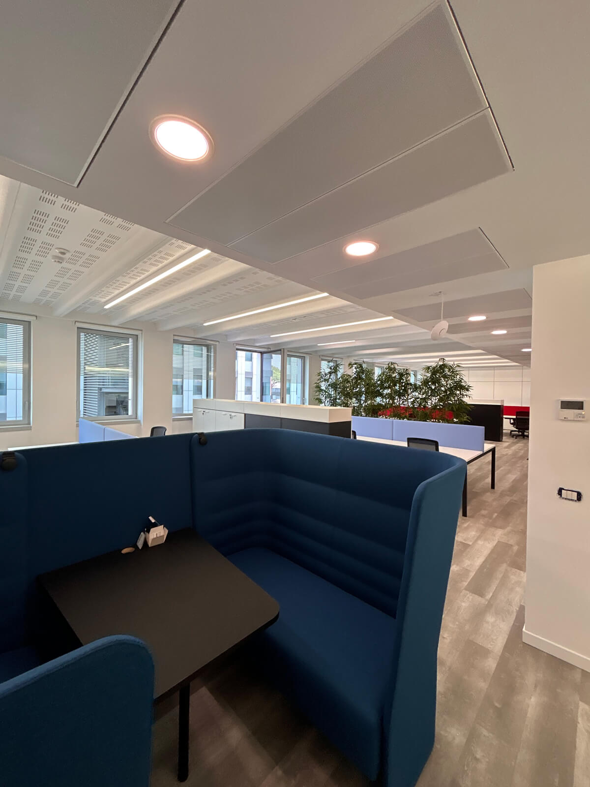 Allestimento ufficio Solco con pareti vetrate, postazioni operative, area lounge e arredi moderni