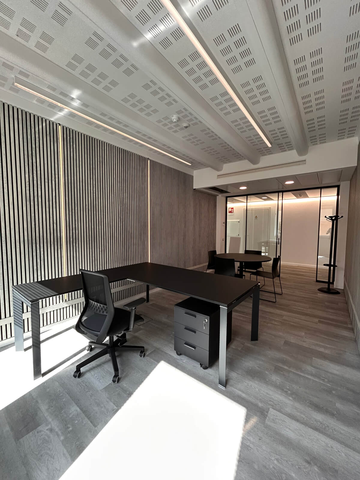 Allestimento ufficio Solco con pareti vetrate, postazioni operative, area lounge e arredi moderni