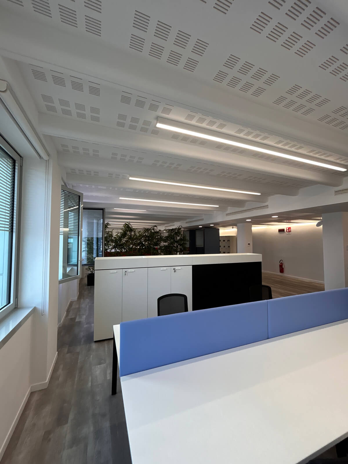 Allestimento ufficio Solco con pareti vetrate, postazioni operative, area lounge e arredi moderni