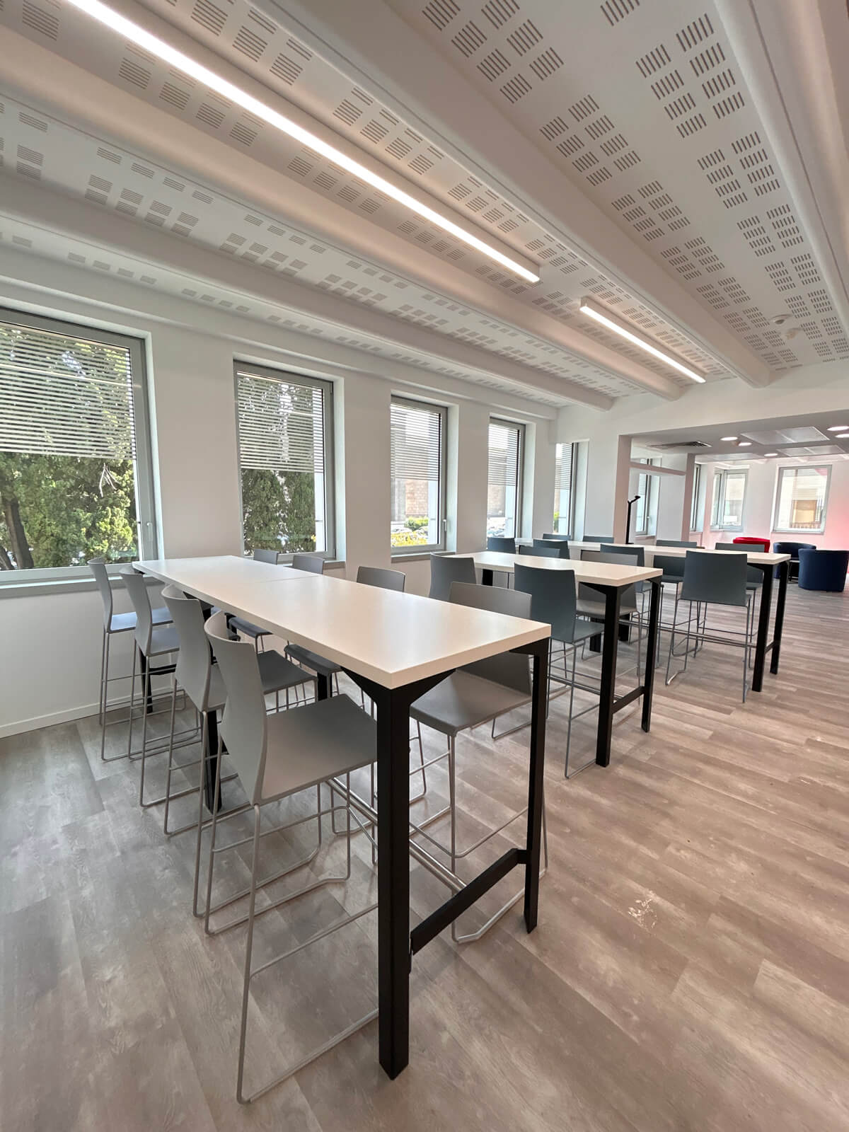 Allestimento ufficio Solco con pareti vetrate, postazioni operative, area lounge e arredi moderni