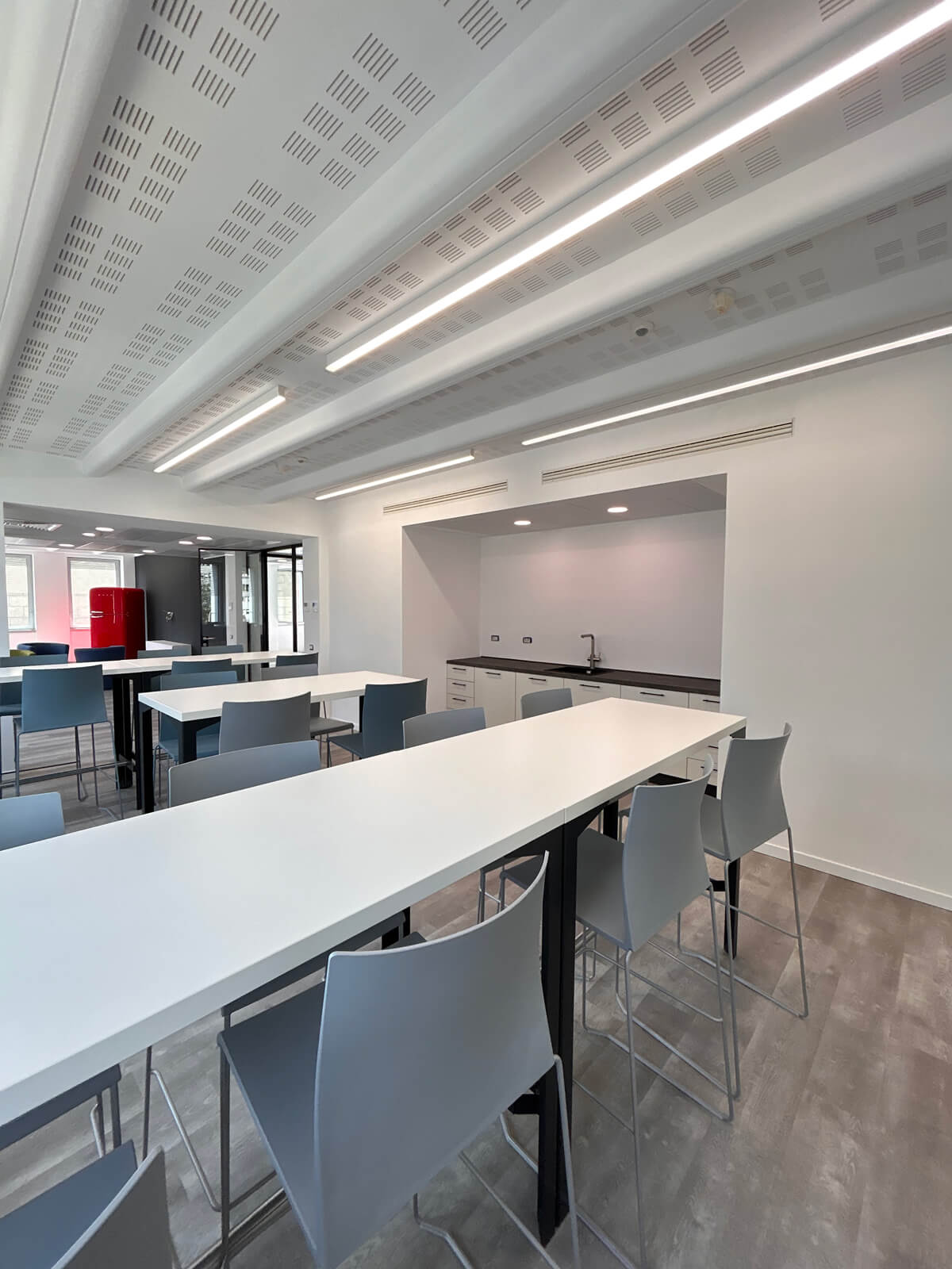 Allestimento ufficio Solco con pareti vetrate, postazioni operative, area lounge e arredi moderni