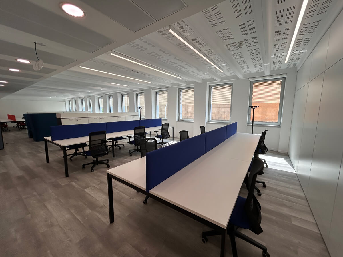 Allestimento ufficio Solco con pareti vetrate, postazioni operative, area lounge e arredi moderni