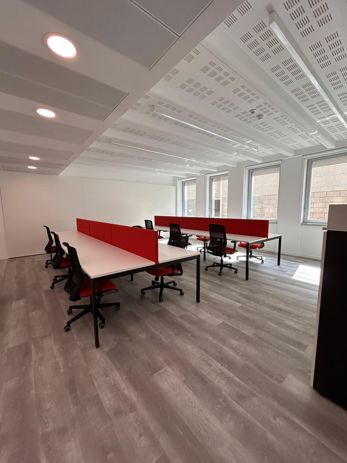 Allestimento ufficio Solco con pareti vetrate, postazioni operative, area lounge e arredi moderni