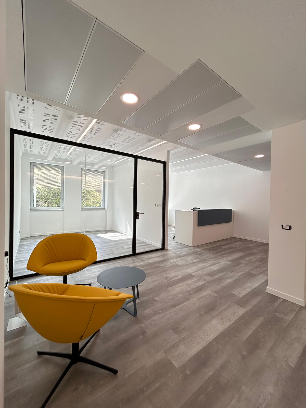 Allestimento ufficio Solco con pareti vetrate, postazioni operative, area lounge e arredi moderni